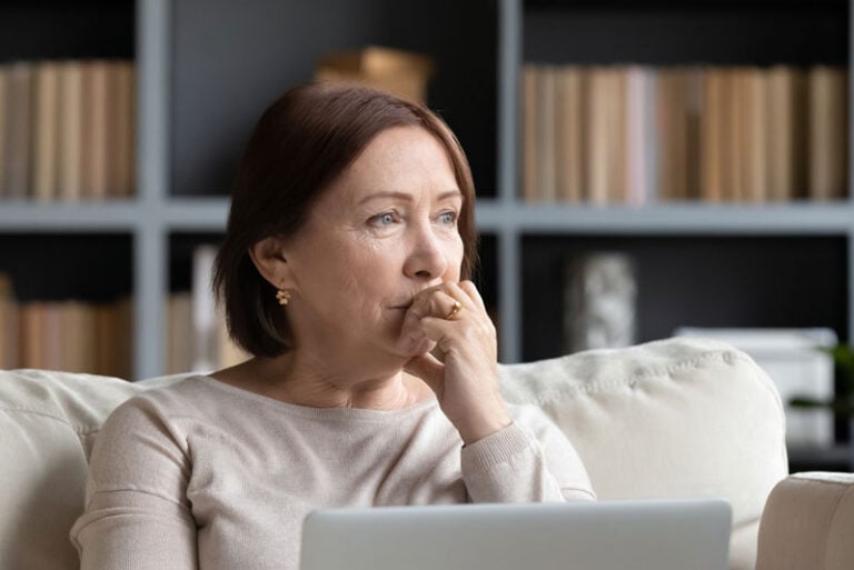 a women deciding on whether to get dental implants or dentures