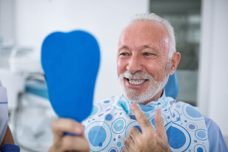 a dental implant patient smiling after implant surgery under sedation