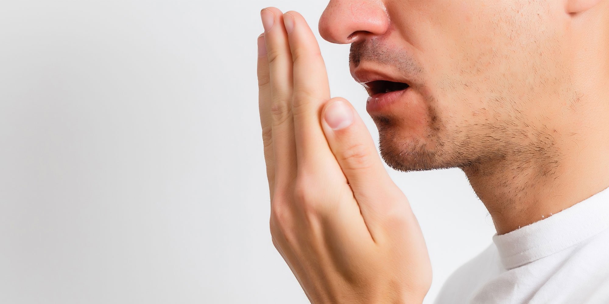 person smelling his own breath