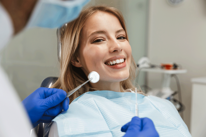 Image of beautiful woman sitting in dental chair while professional doctor fixing her teeth.